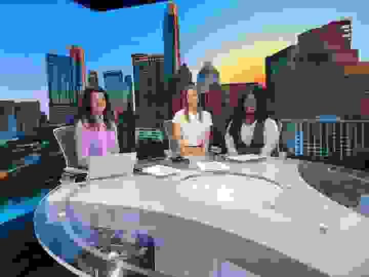 Stephanie and Ki'ana sitting at a news desk with Katie Jackson, in front of a screen showing the Austin skyline. Stephanie and Ki'ana sitting at a news desk with Katie Jackson, in front of a screen showing the Austin skyline.