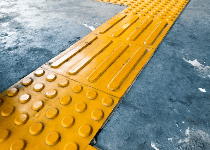 A close up of yellow integrated warning type and directional type TGSIs