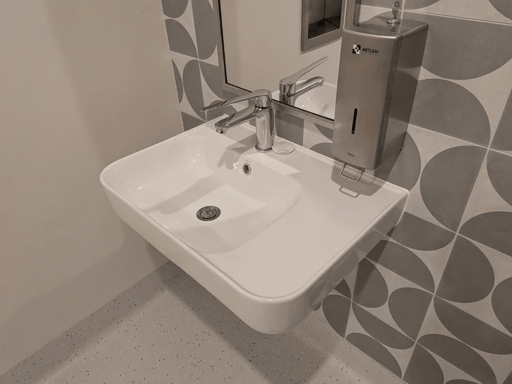 A female DDA Access Consultant. standing looking at her tablet PC while inspecting a building