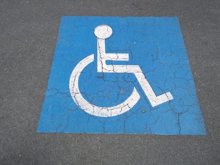 Architectural drawings on a table, rolled out with a ruler across them, and a 3D frame of a large building projecting out of the drawings