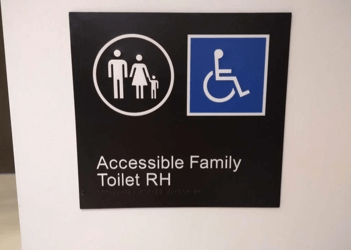 A braille and tactile sign saying Accessible Family Toilet RH