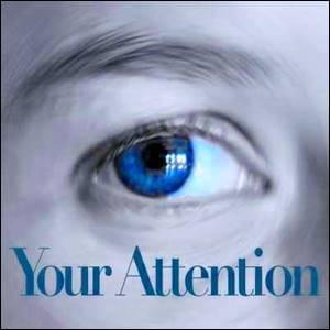 The right eye of a person with the words Your Attention below it