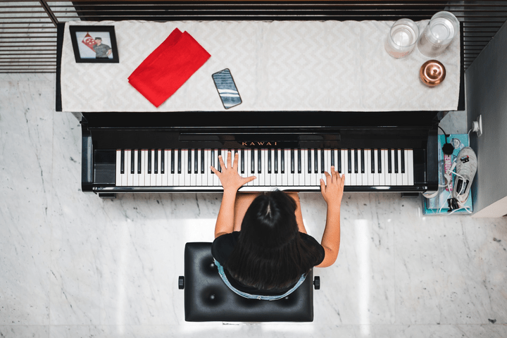 Student sitting and playing the piano.