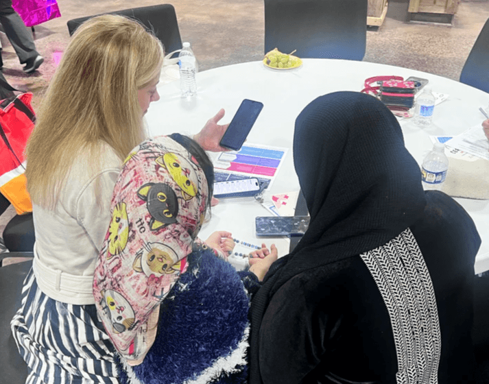 Young girl playing with wooden bead maze toy on floor of child care center
