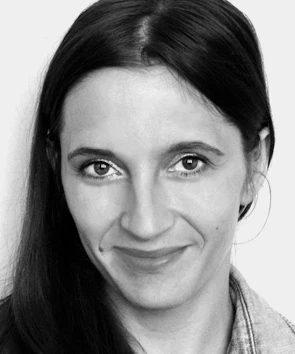 Czarno- białe zdjęcie młodej uśmiechniętej kobiety z długimi włosami 