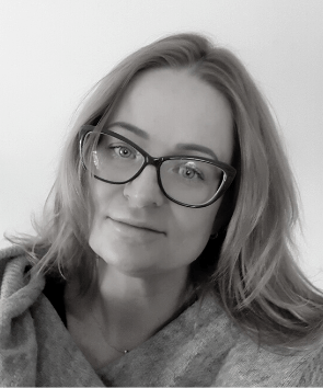 Czarno- białe zdjęcie lekko uśmiechniętej kobiety z długimi włosami 