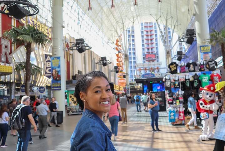 Woman smile at the Fremont Street Experience in the daytime in a protective hairstyle