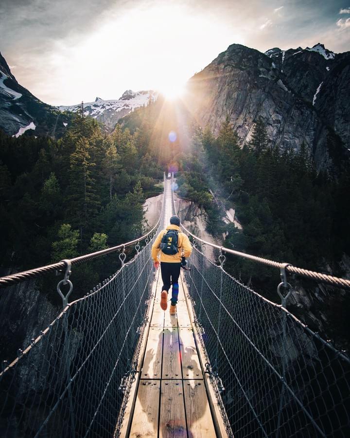 Man walking on a long bridge as an accomplishment