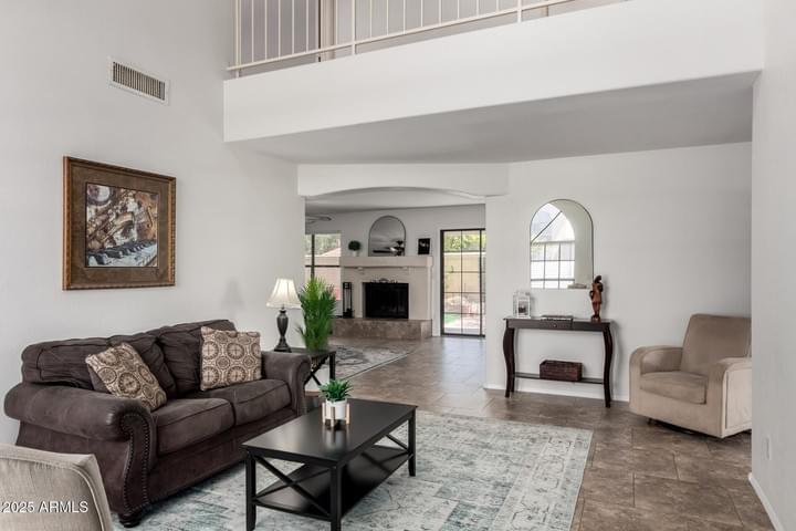 Bright front living room with vaulted ceilings and natural light in family-friendly Gilbert AZ home for sale.