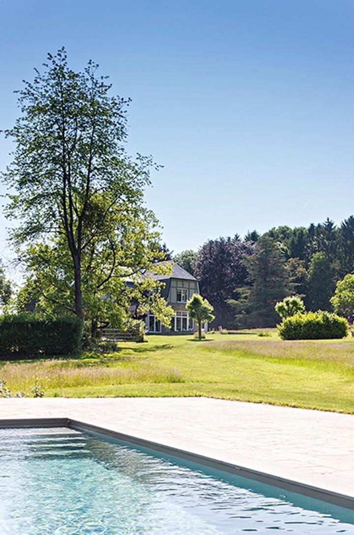 La piscine est située en contrebas, en lisière de fôret.