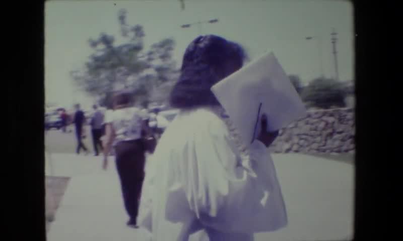 1983: Lansing Michigan. Women Student Graduation Ceremony Walking Away.