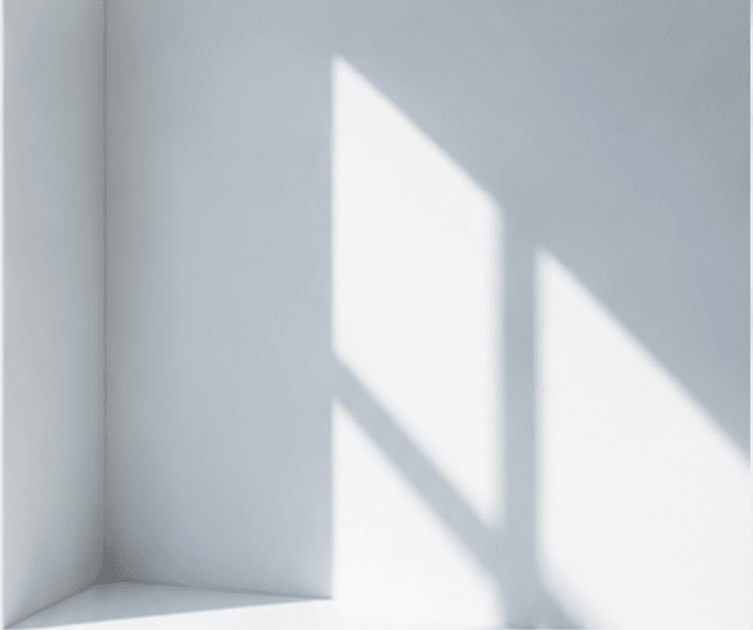 Soft daylight casting geometric window shadows on a pale wall