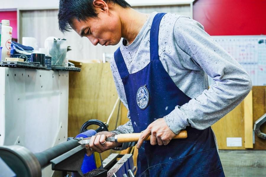 鄧師傅在車床前手工製桿