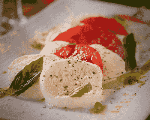 Fresh mozzarella slices layered with tomatoes and basil. Fresh mozzarella slices layered with tomatoes and basil.