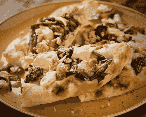 Fresh mozzarella melted on a flatbread with sausage and greens. Fresh mozzarella melted on a flatbread with sausage and greens.