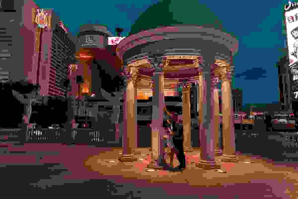 Couple posing for photos on the Las Vegas Strip during their elopement, with iconic hotels and neon lights in the background.