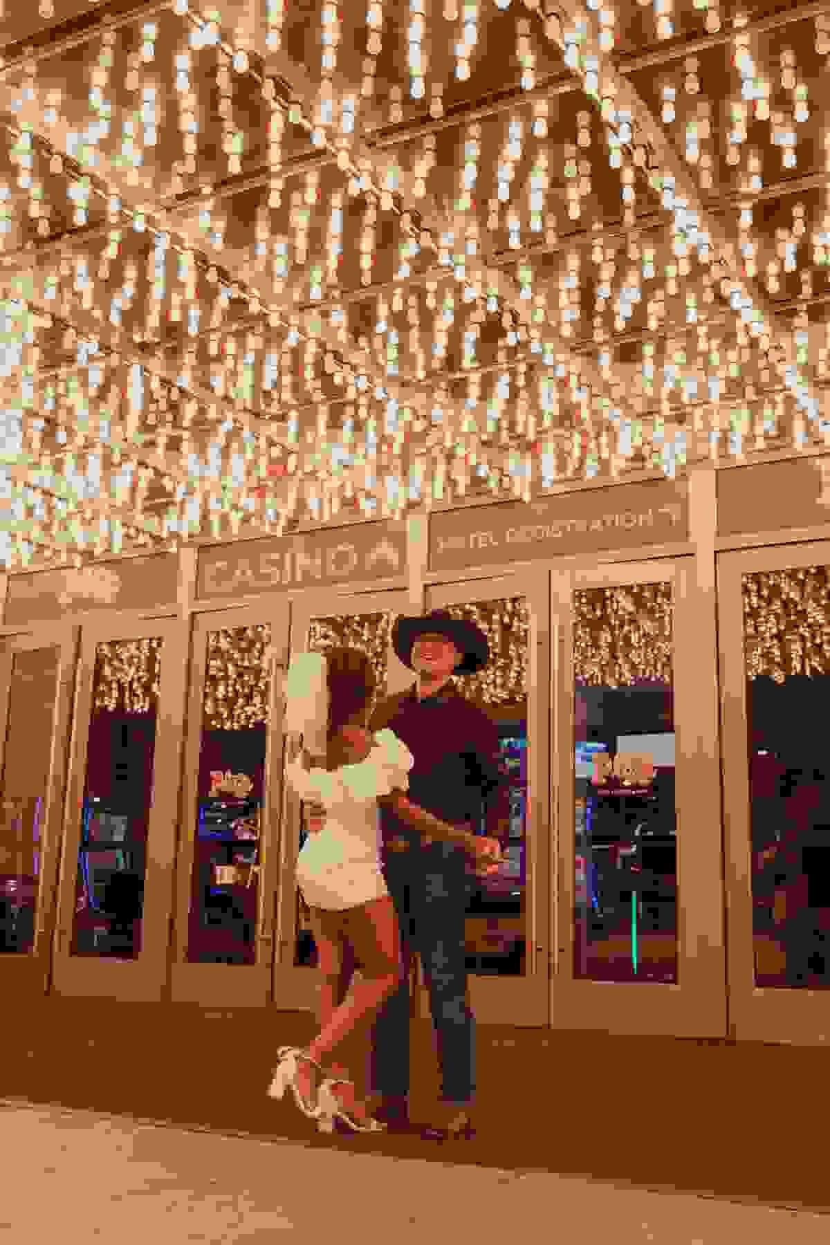 Couple dancing under neon lights on Fremont Street in Las Vegas during their wedding or elopement photo session.