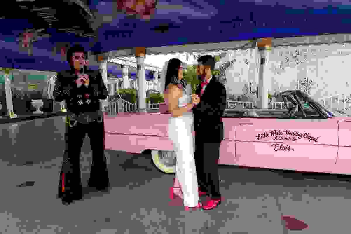Couple getting married at the Little White Chapel in Las Vegas with Elvis impersonator officiating their ceremony.