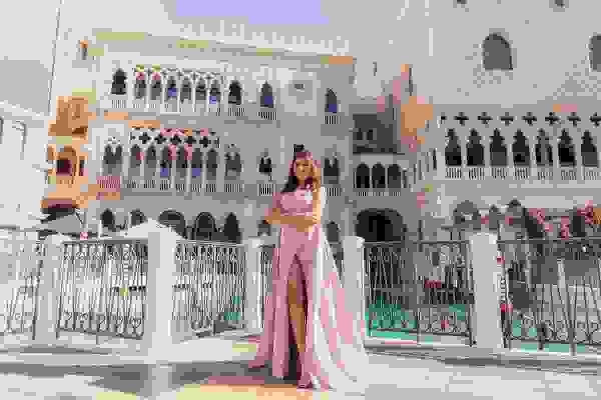 Woman standing in front of the Venetian hotel in Las Vegas, highlighting the hotel’s elegant architecture and romantic photo setting.