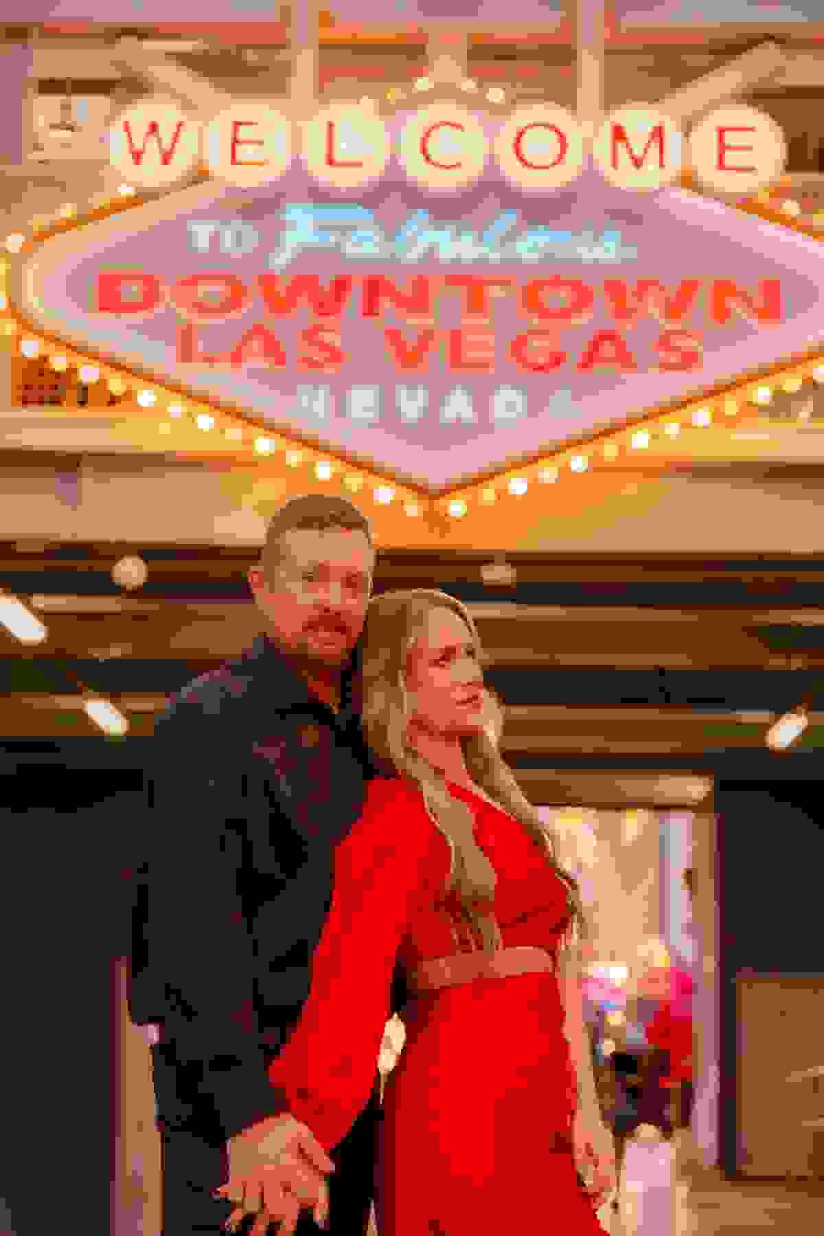 Couple standing in front of the Fremont Street Experience welcome sign, a must-visit Las Vegas photo location.