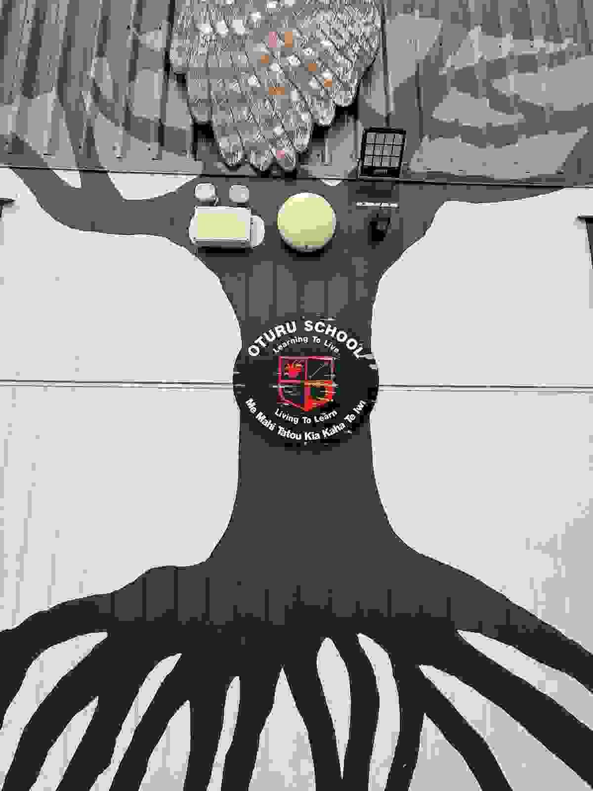 A Tree painted on tne sidfe of a school in Aotearoa featuring the shield for Oturo school A Tree painted on tne sidfe of a school in Aotearoa featuring the shield for Oturo school