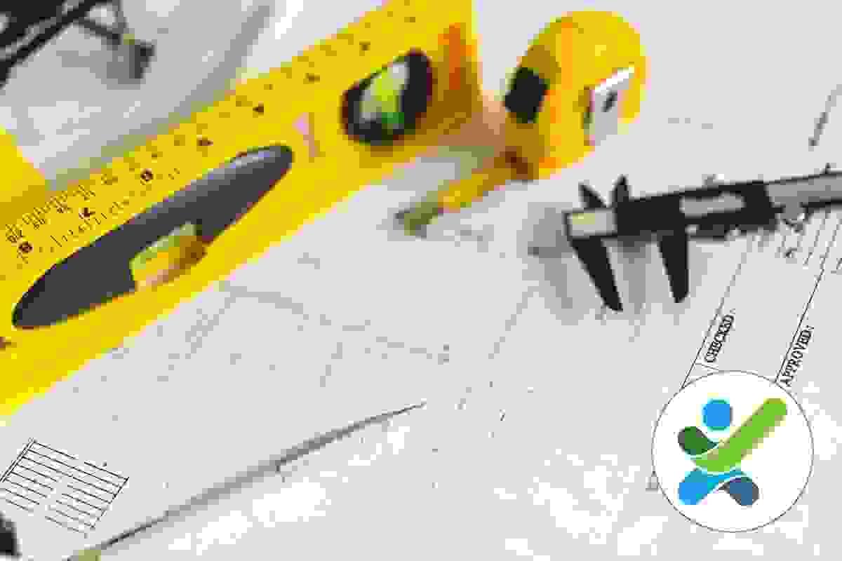 A tape measure, pencil, level and vernie calipers are placed on top of an architectural drawing A tape measure, pencil, level and vernie calipers are placed on top of an architectural drawing