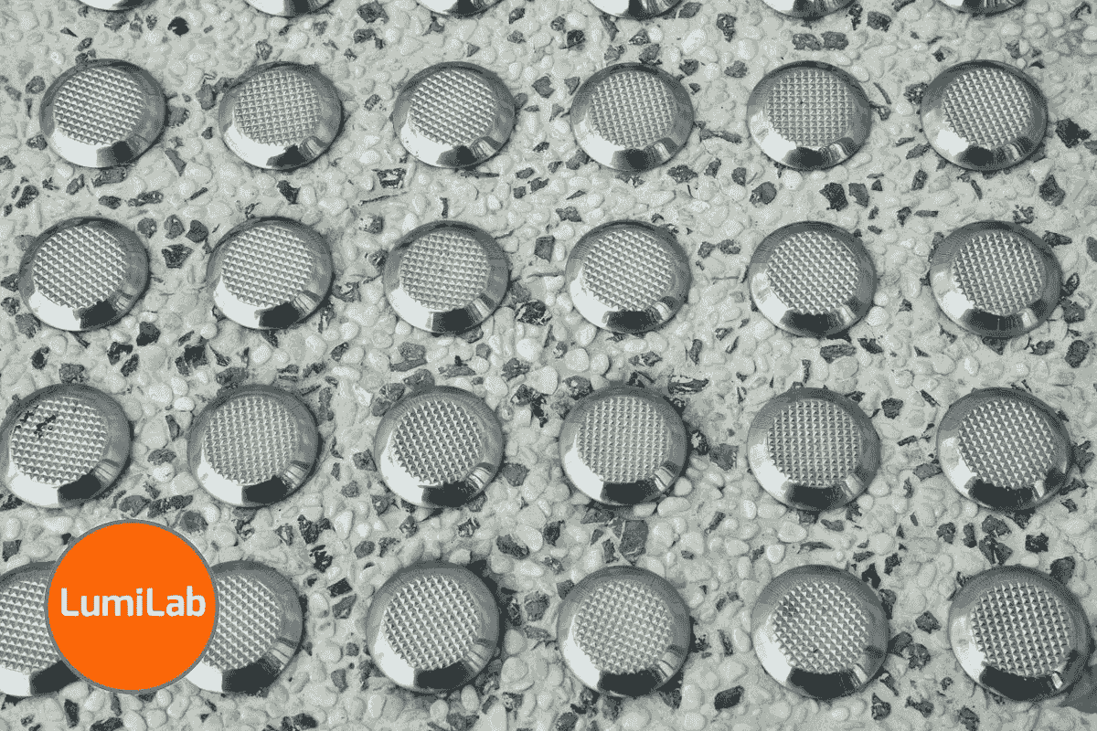 Close-up image of Tactile Ground Surface Indicators on a pebble-textured flooring Close-up image of Tactile Ground Surface Indicators on a pebble-textured flooring