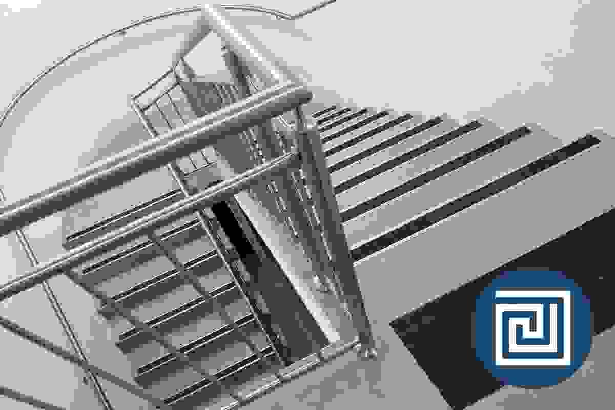 A view looking down a modern stairway with stainless steel handrails, black tread nosing strips and black tactile indicators A view looking down a modern stairway with stainless steel handrails, black tread nosing strips and black tactile indicators