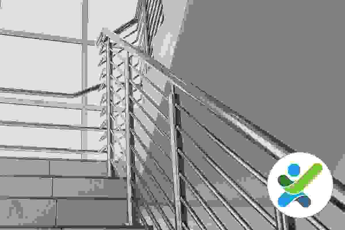 A view looking up a modern stairway with a single stainless steel handrail A view looking up a modern stairway with a single stainless steel handrail