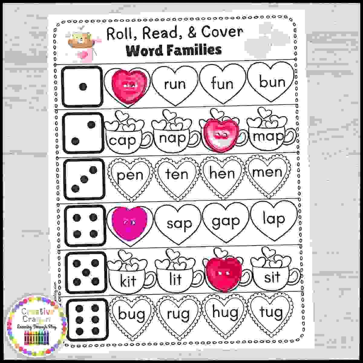 CVC word reading and covering game for Valentine’s Day kindergarten literacy center with dice and printable word mats.