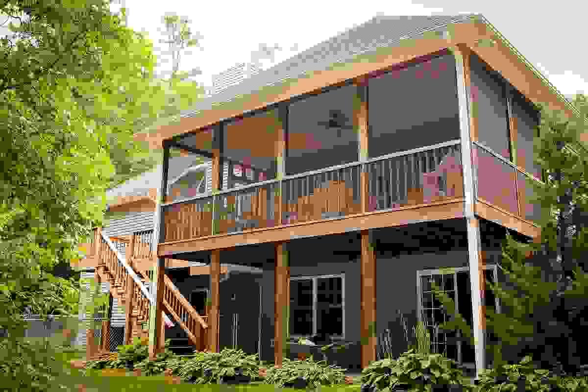 Multilevel custom-made covered porch and deck with stairs and railings surrounded by trees in Roanoke VA