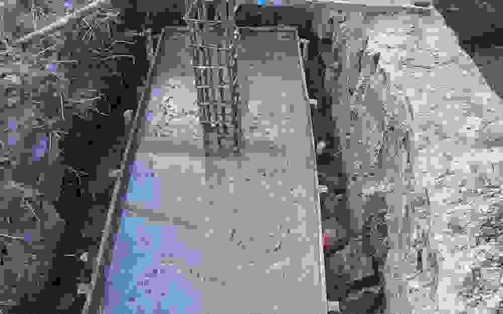 wet concrete footing just poured into footing form with rebar wet concrete footing just poured into footing form with rebar