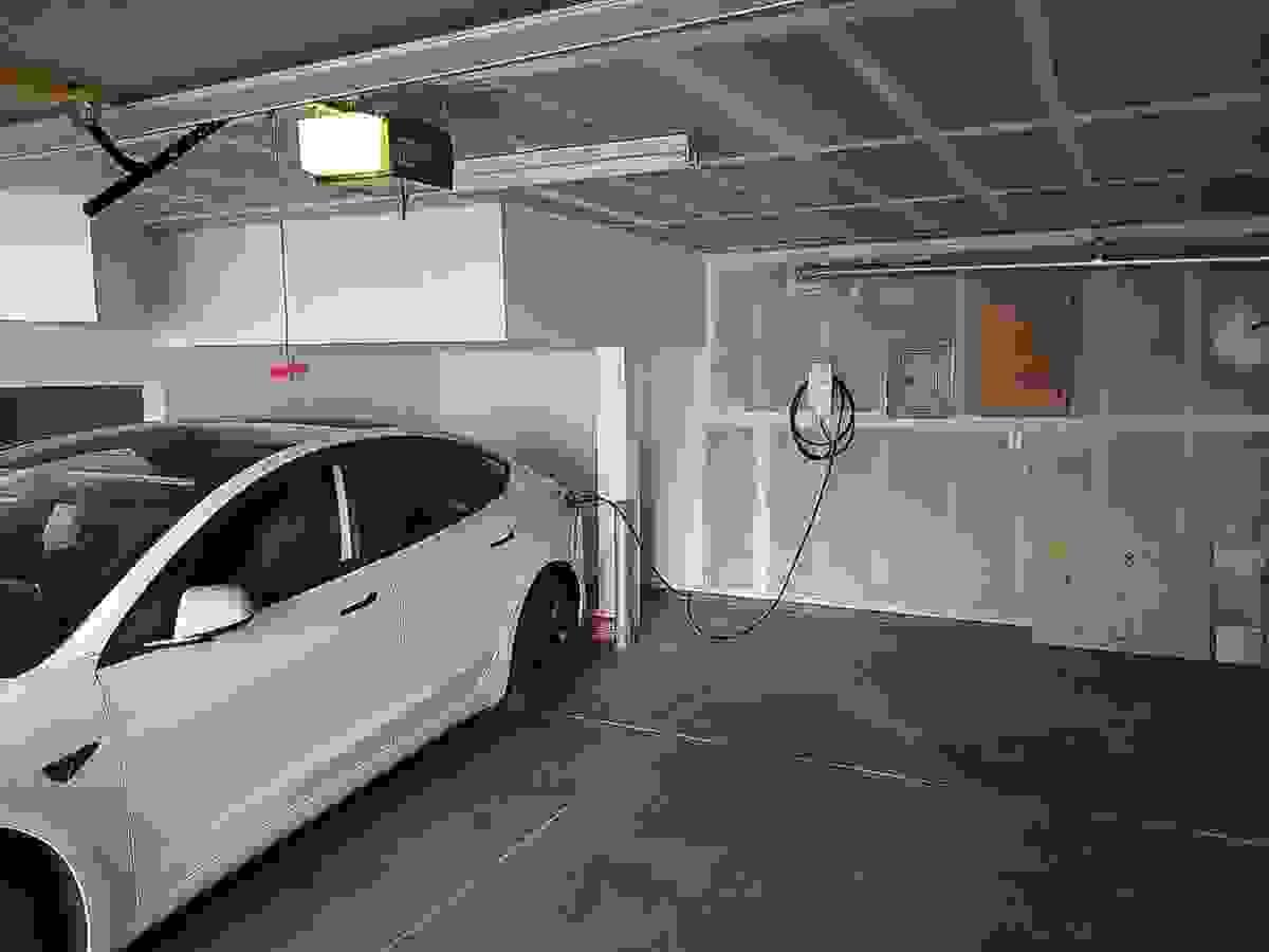 Residential EV Charger In Garage Plugged Up To Car Residential EV Charger In Garage Plugged Up To Car