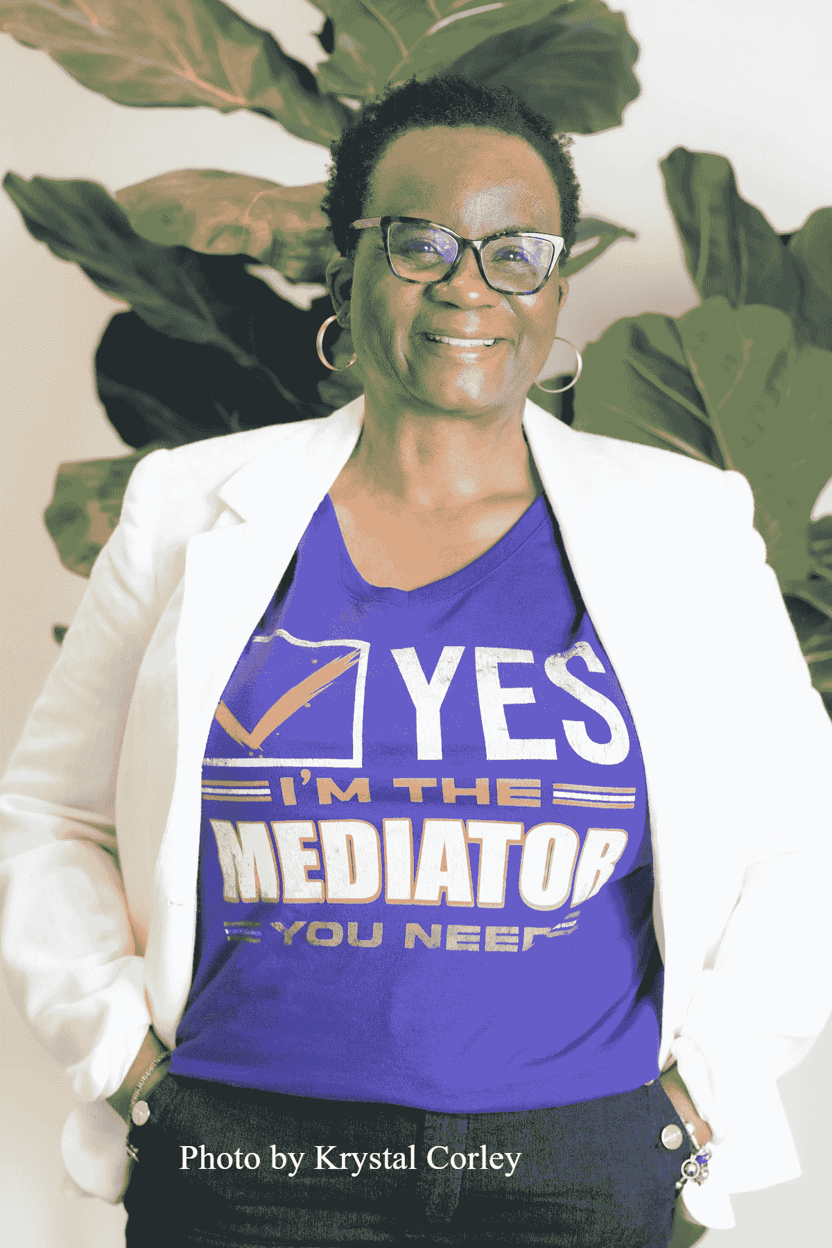 Woman with glasses smiling wearing white blazer and tshirt that says "Yes I 'm the Mediator You Need" Woman with glasses smiling wearing white blazer and tshirt that says "Yes I 'm the Mediator You Need"