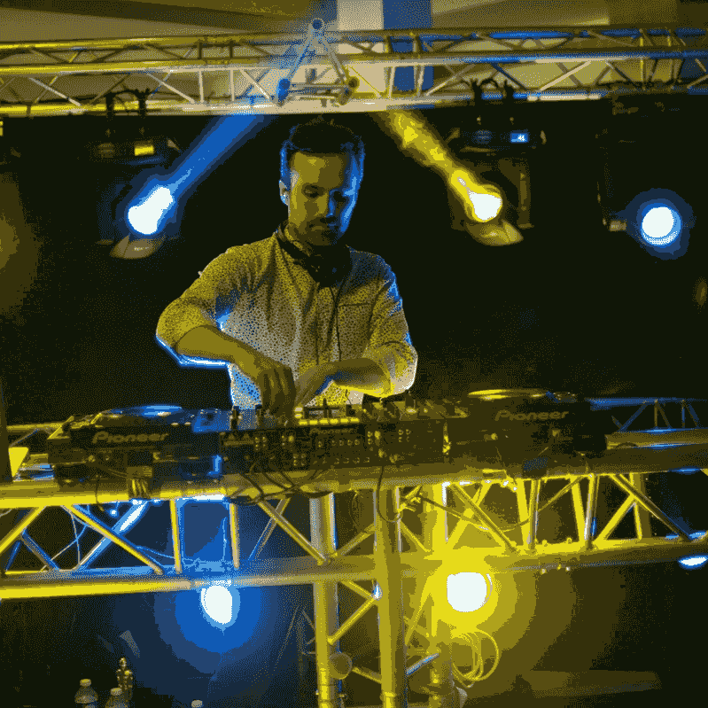 DJ en train de mixer avec plusieurs projecteurs derrière lui DJ en train de mixer avec plusieurs projecteurs derrière lui