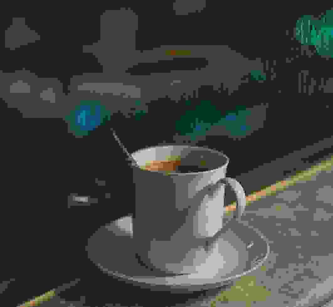 Cozy scene of a hot cup of coffee by a rainy window with blurred city bokeh in the background. Cozy scene of a hot cup of coffee by a rainy window with blurred city bokeh in the background.