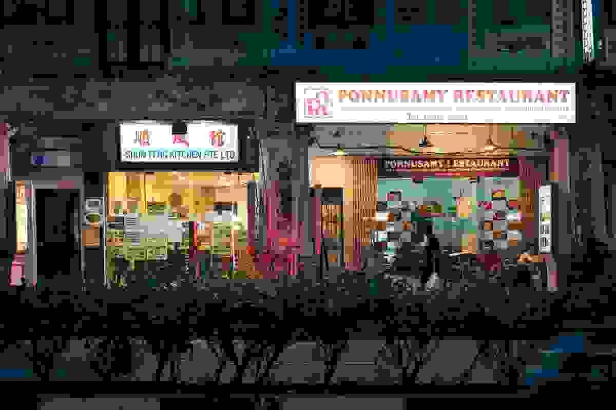Night view of side-by-side Singapore eateries, including a traditional Asian restaurant and Ponnusamy Restaurant, highlighting the diverse local food scene. Night view of side-by-side Singapore eateries, including a traditional Asian restaurant and Ponnusamy Restaurant, highlighting the diverse local food scene.