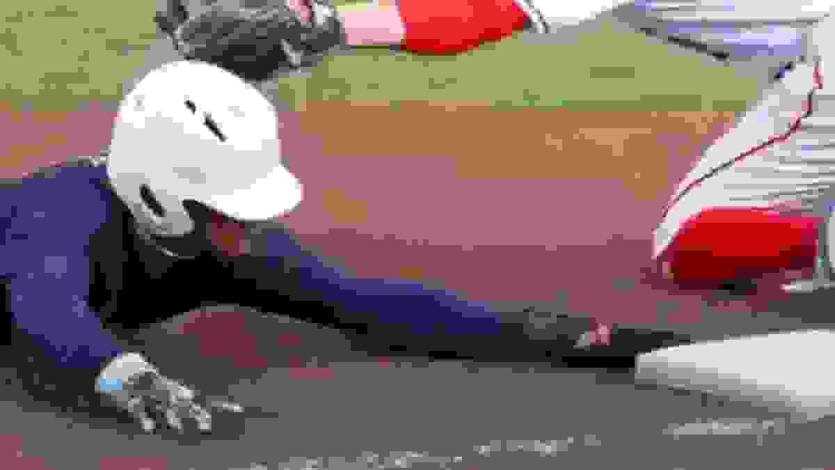 A player sliding into third base to beat the throw. A player sliding into third base to beat the throw.