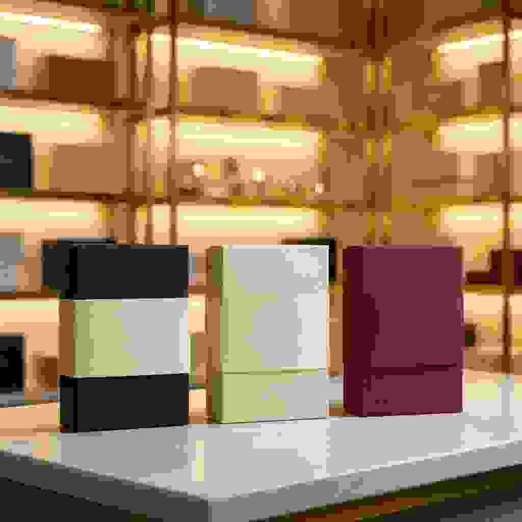 Standard packaging sleeves (belly bands) wrapped around rigid boxes on a marble counter in a luxury showroom. Standard packaging sleeves (belly bands) wrapped around rigid boxes on a marble counter in a luxury showroom.