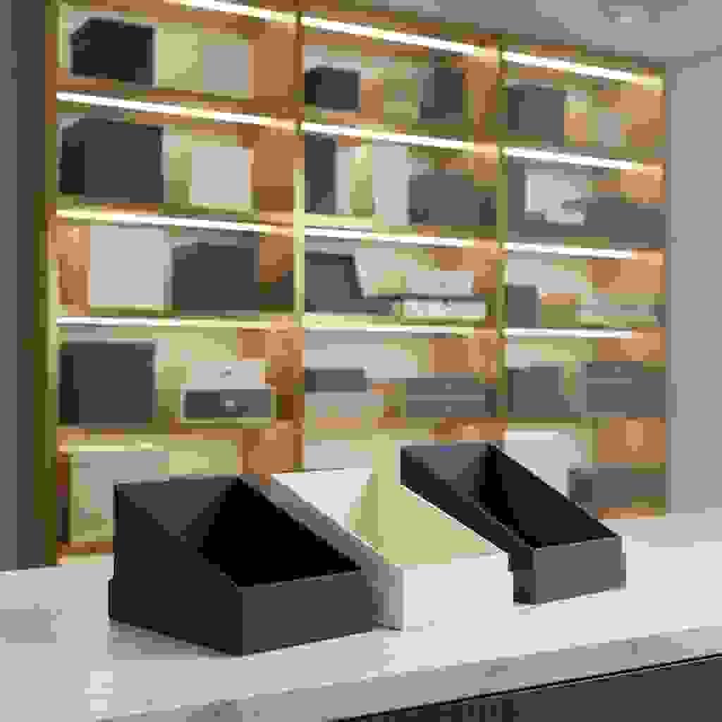 Countertop display boxes on a marble counter with backlit shelves filled with premium packaging boxes. Countertop display boxes on a marble counter with backlit shelves filled with premium packaging boxes.