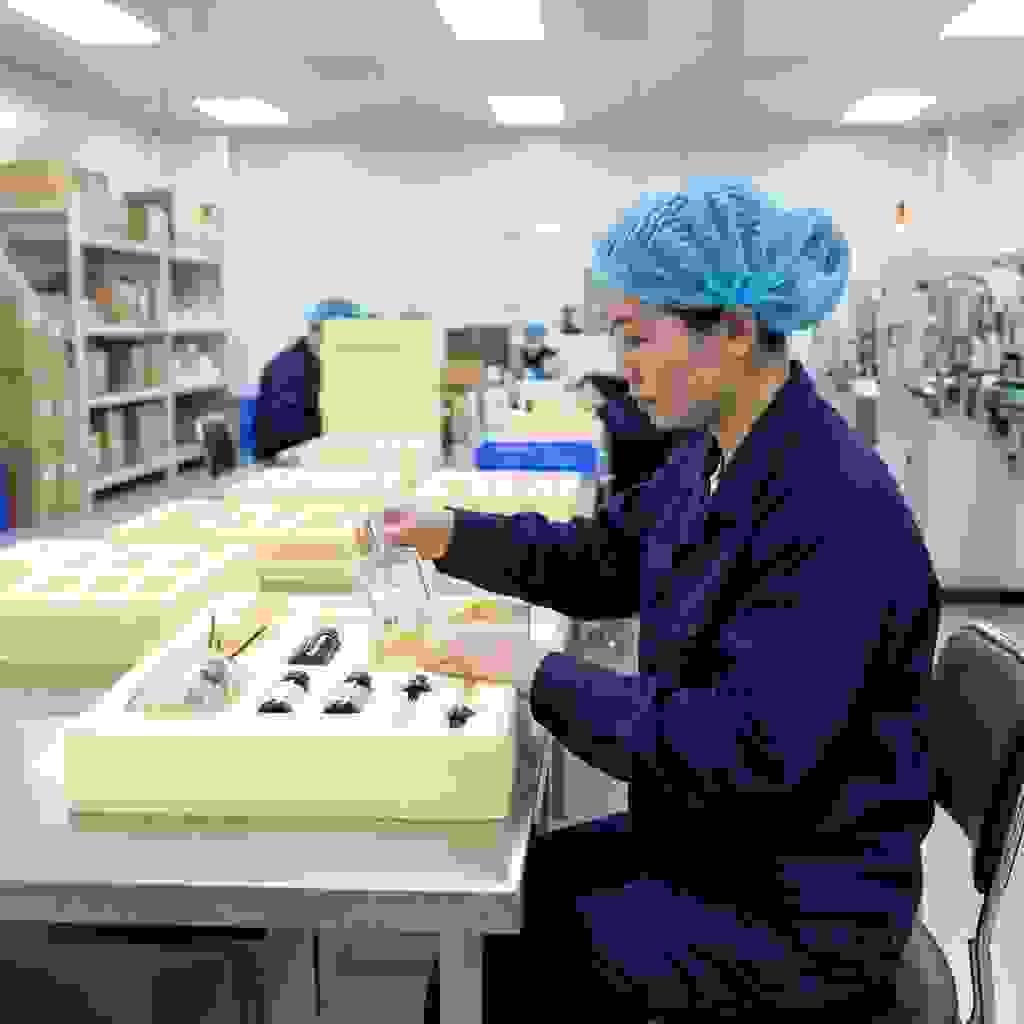 Foam insert for fragrance bottles being inspected by Chinese factory worker Foam insert for fragrance bottles being inspected by Chinese factory worker