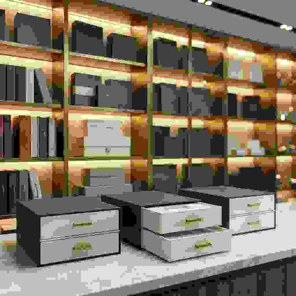 Three two-tier drawer boxes on a marble counter, with one top drawer partially opened to show the stacked layers and insert. Three two-tier drawer boxes on a marble counter, with one top drawer partially opened to show the stacked layers and insert.