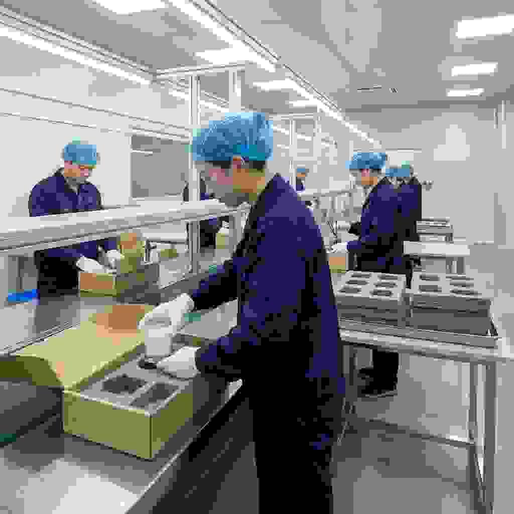 Workers installing EVA foam inserts in rigid boxes to protect glass candle jars and fragile home décor items. Workers installing EVA foam inserts in rigid boxes to protect glass candle jars and fragile home décor items.