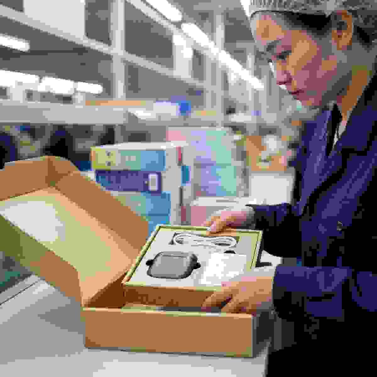 Paperboard tray insert in a rigid box being fitted at a Chinese packaging factory workstation. Paperboard tray insert in a rigid box being fitted at a Chinese packaging factory workstation.