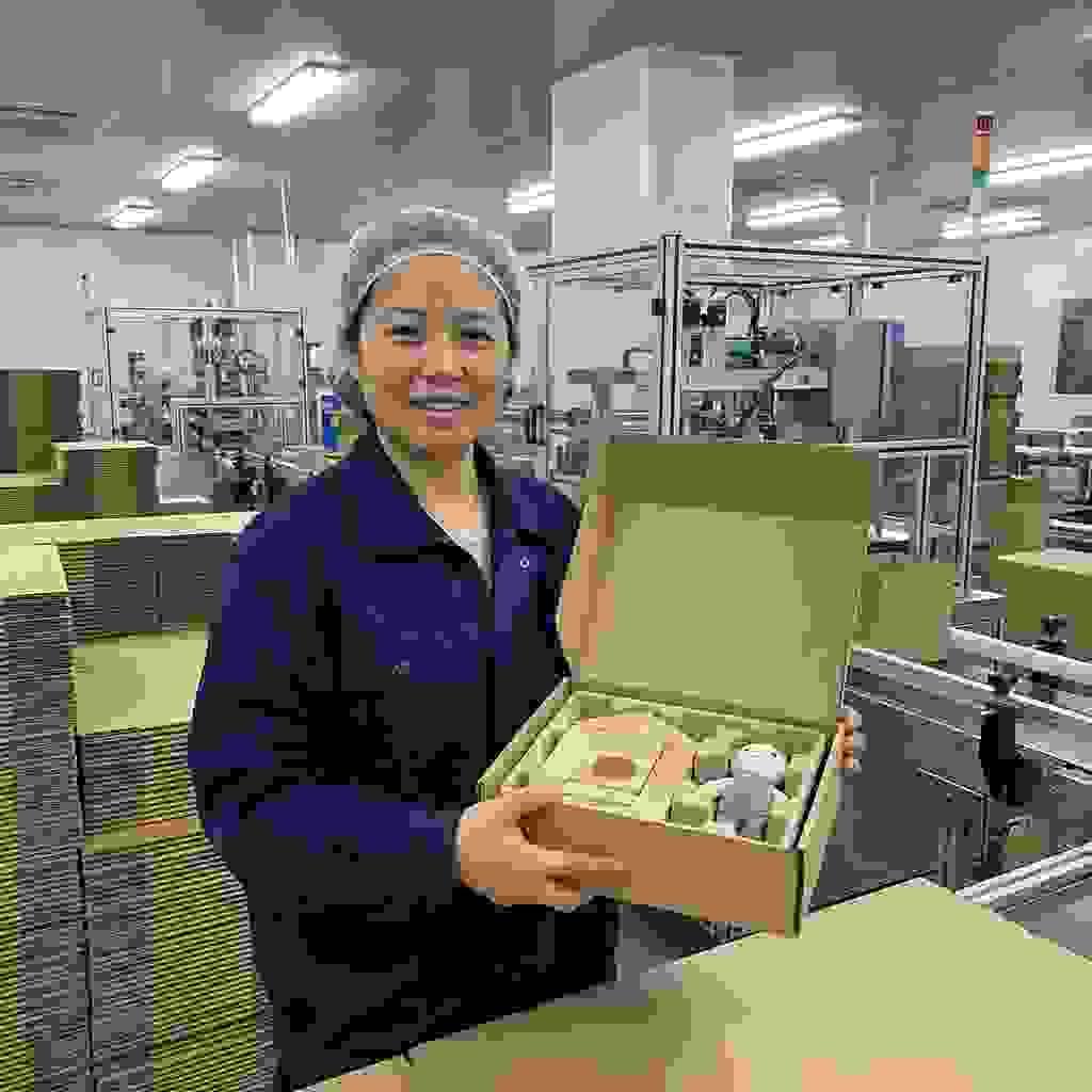 Worker displaying an eco-friendly molded pulp insert used for toys and gift packaging inside a Chinese factory. Worker displaying an eco-friendly molded pulp insert used for toys and gift packaging inside a Chinese factory.