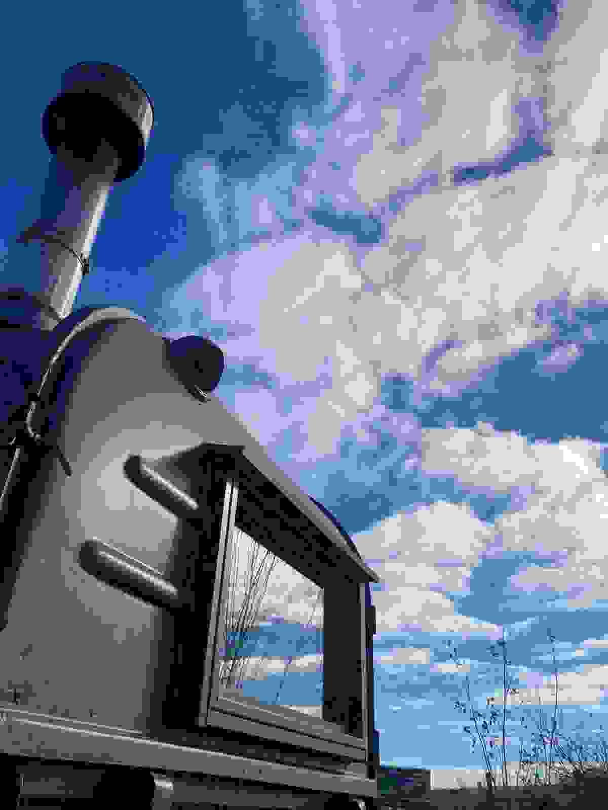 HorsA black horsebox sauna with blue sky and fluffy clouds both overhead and reflected in it's window. HorsA black horsebox sauna with blue sky and fluffy clouds both overhead and reflected in it's window.