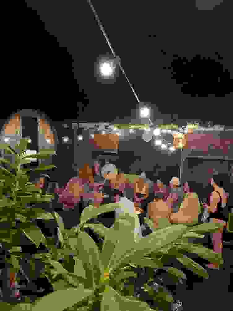 A group in sauna hats, swimmers and towels listen to a drum playing at a sauna ritual. A group in sauna hats, swimmers and towels listen to a drum playing at a sauna ritual.
