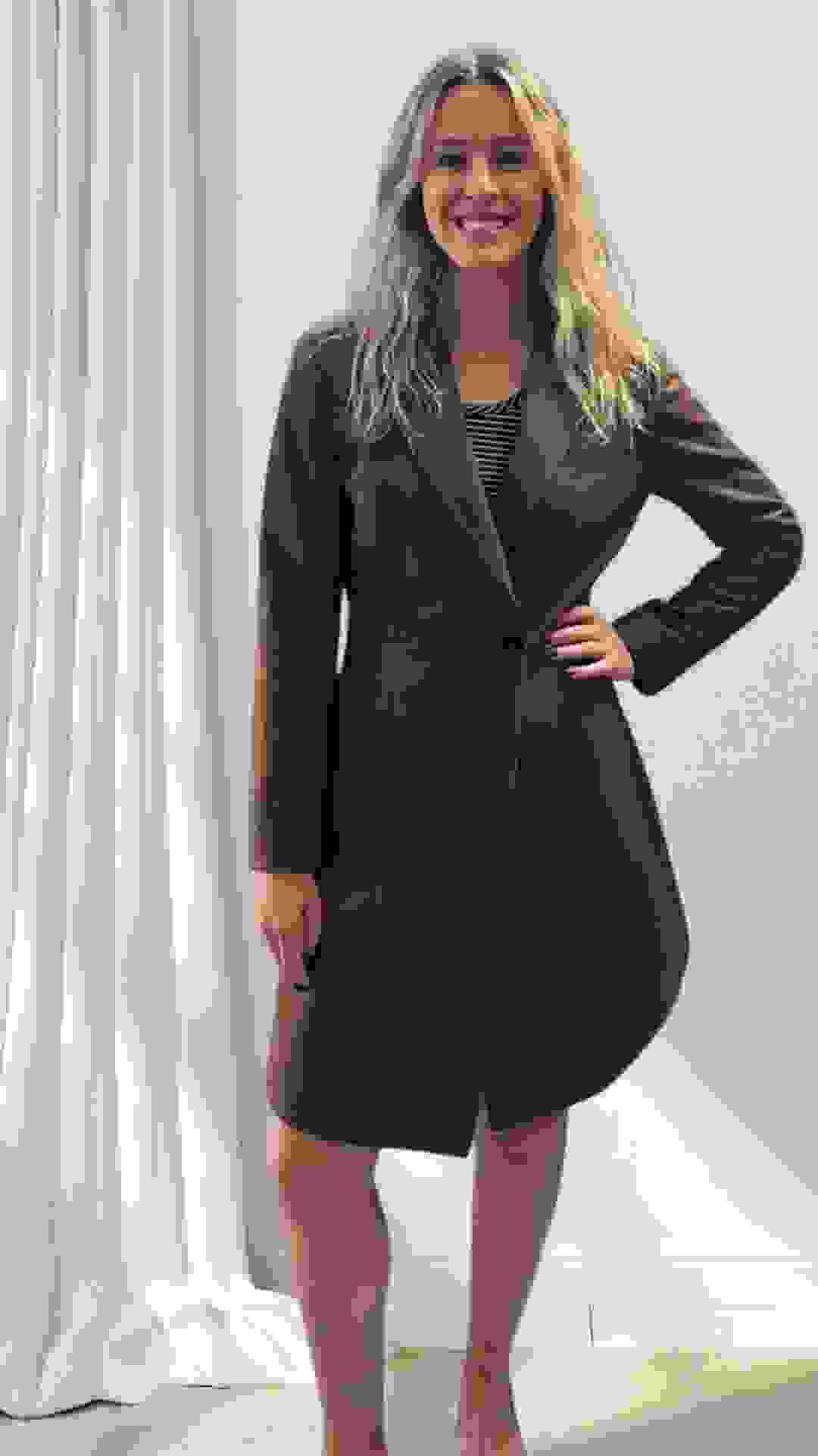 New visitor styled for exploration — in a perfectly fitted coat-dress, with long blonde hair and a big smile as the only accessories needed.