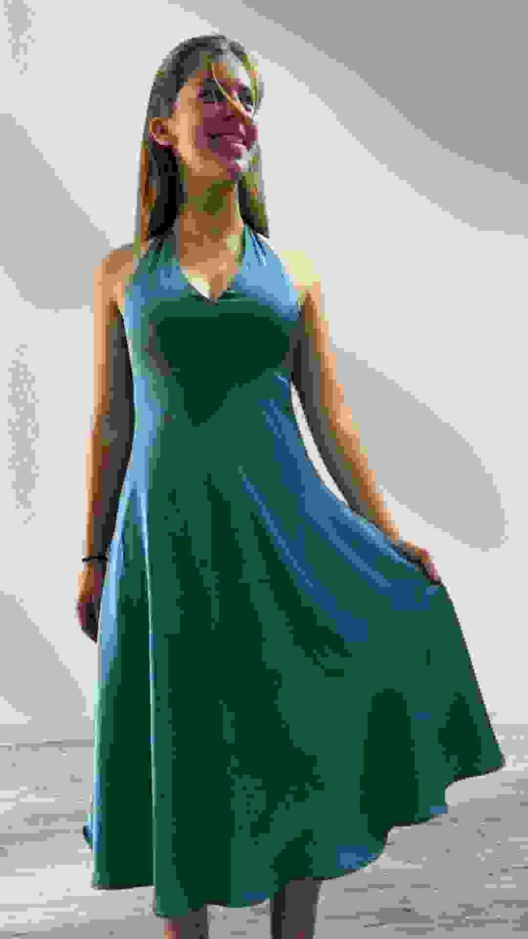 The ease of summer vacations in silk shine through for this young woman who wears a halter neck dress that's as light as a summer's day.
