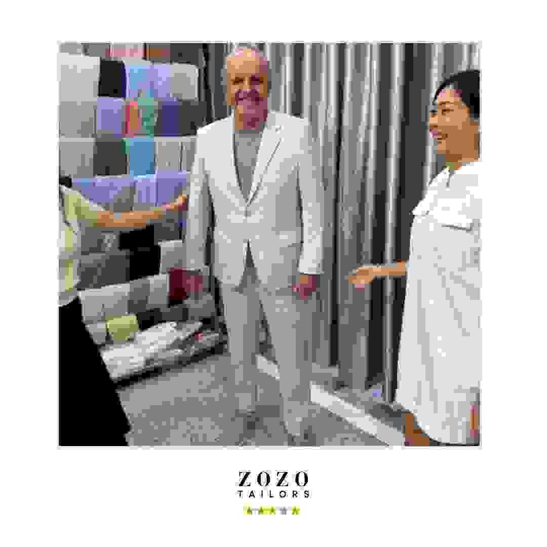 Client and tailor during final fitting of bespoke linen suit. Client and tailor during final fitting of bespoke linen suit.